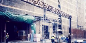a group of people standing outside of a building under construction