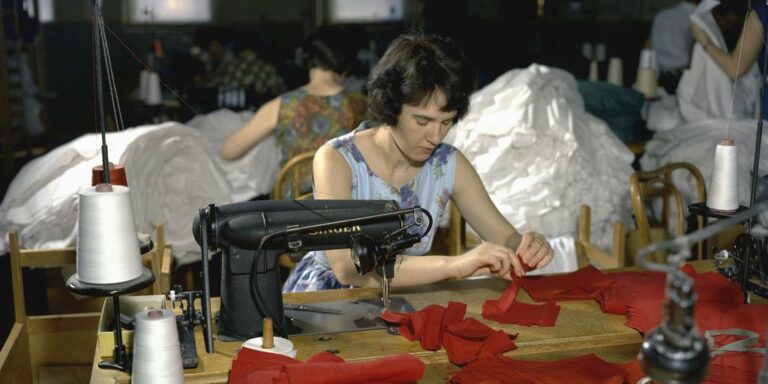 a woman sitting at a table with a sewing machine