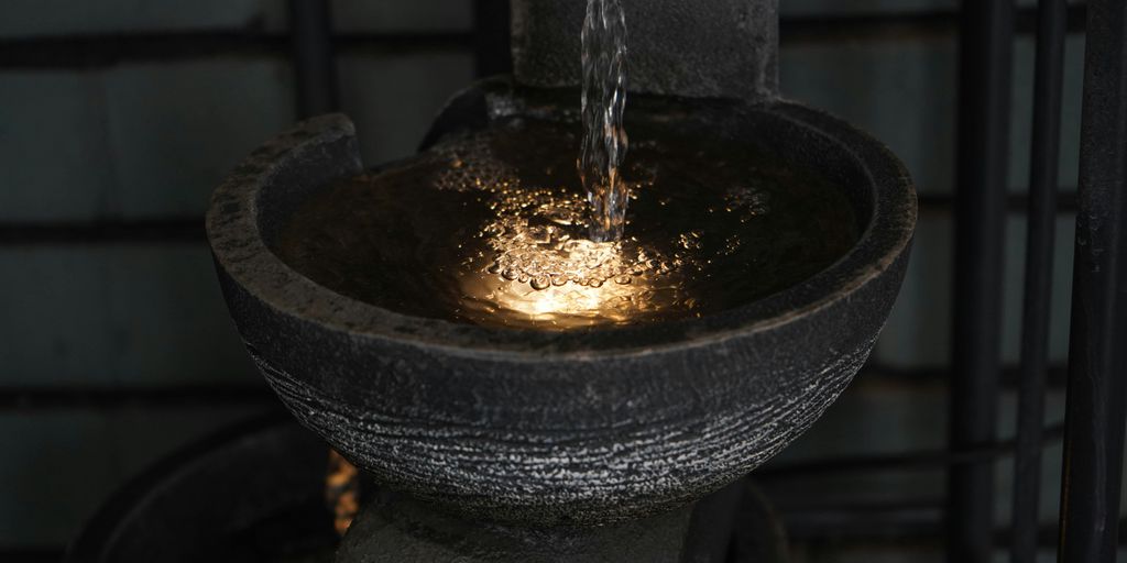 a close up of a fountain with water pouring from it