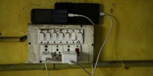 Phones are charging on an electrical outlet.