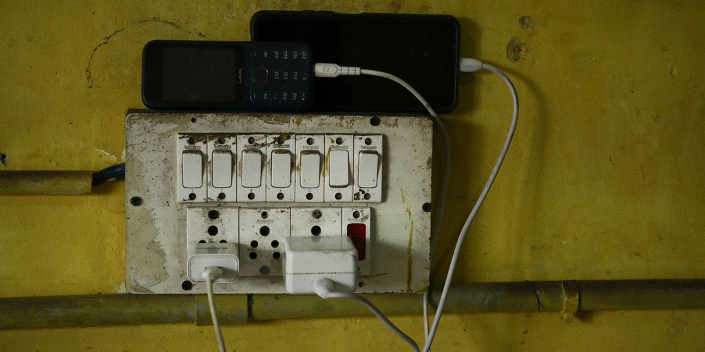 Phones are charging on an electrical outlet.