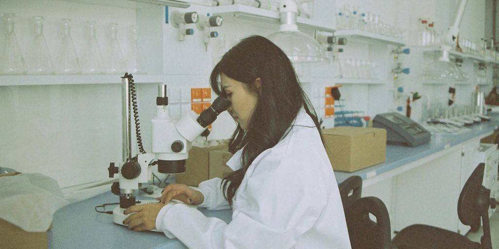 woman in white long sleeve shirt using white and black sewing machine