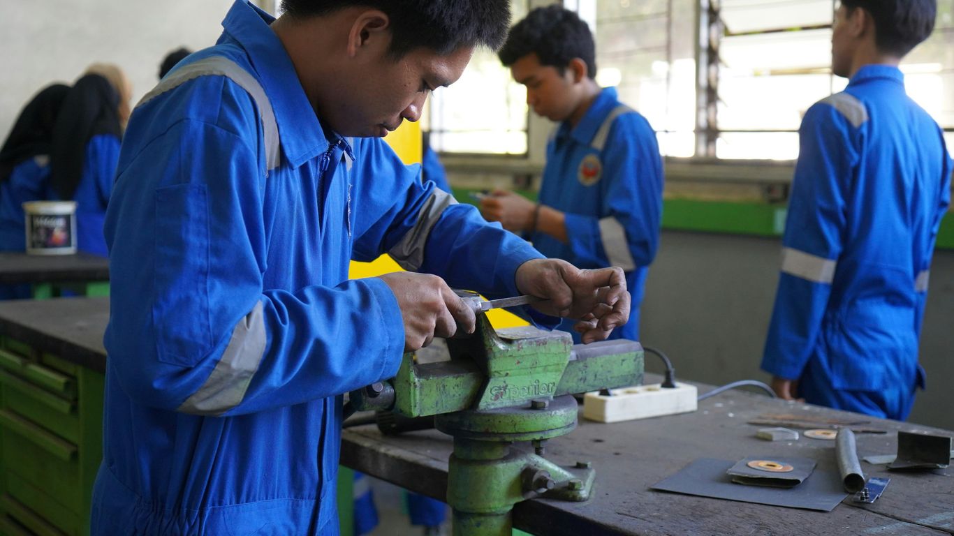 a group of men working on a piece of metal