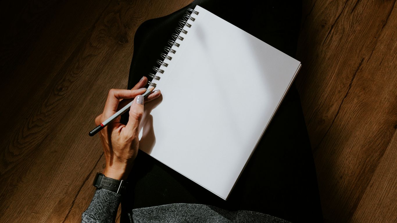 person writing on white paper