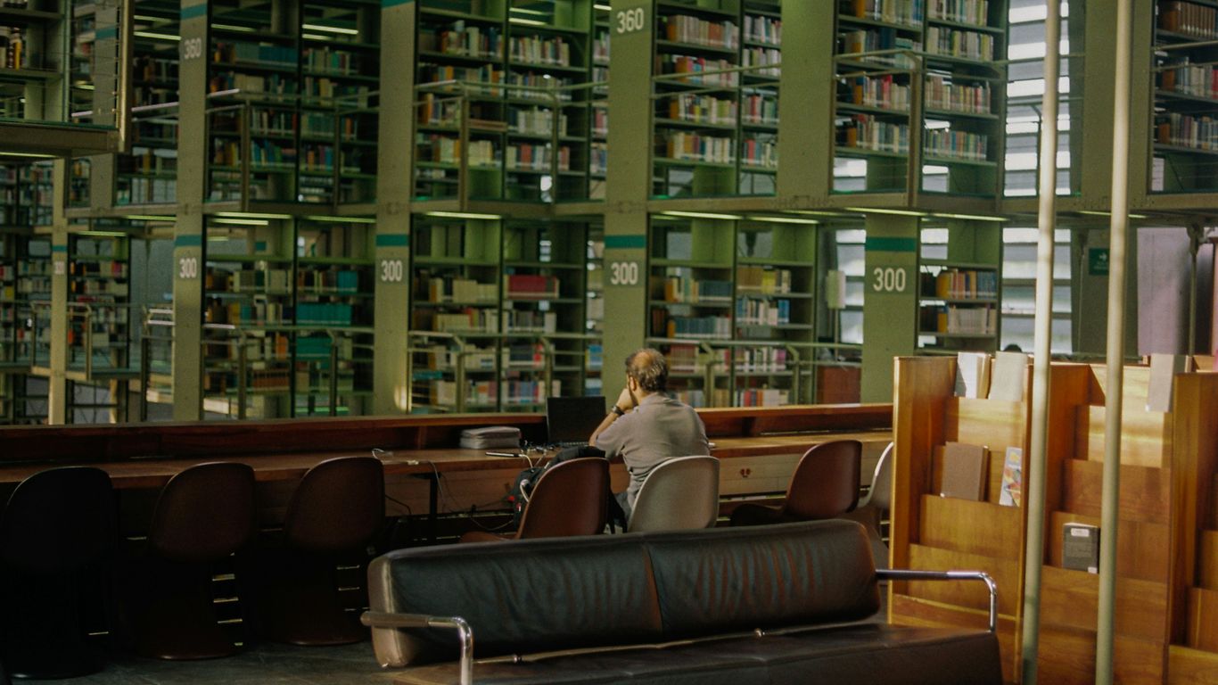 a person sitting at a table in a library